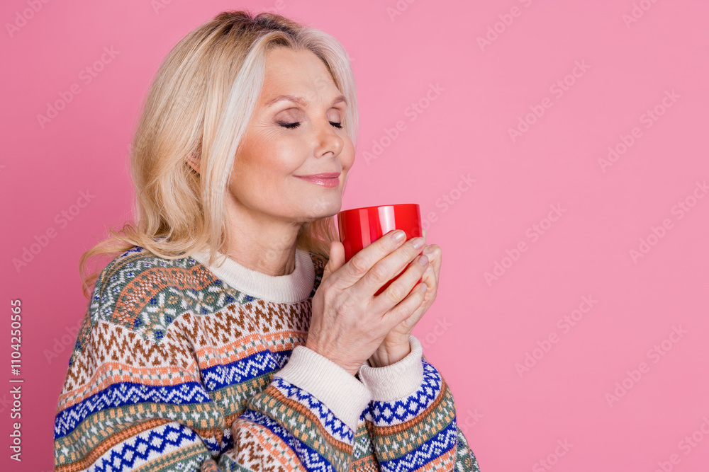 Portrait of nice aged woman smell coffee empty space wear sweater isolated on pink color background Portrait of nice aged woman smell coffee empty space wear sweater isolated on pink color background