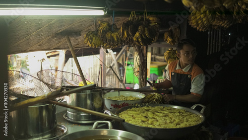 Indonesian Man's hand, making banana frying puff pastry, the outside of the pastry is made of flour for cooking, and the inside of the pastry is made of bananas. Backgound Banana Indoneis