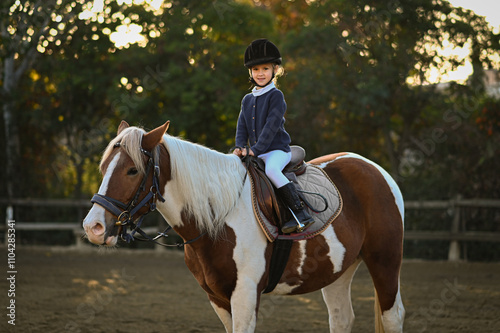 Young girl riding a horse in a traditional stable, embodying the classic bond between rider and steed