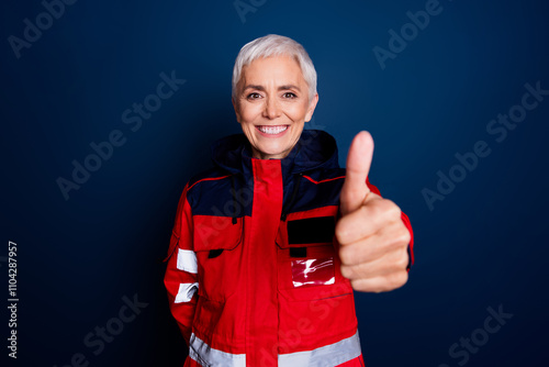 Photo of attractive mature female approve thumb up wear uniform paramedic doc insurance assistance isolated on dark blue color background photo