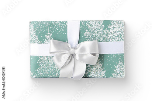 A beautifully wrapped gift with a silver bow on a green and white patterned paper featuring trees. photo