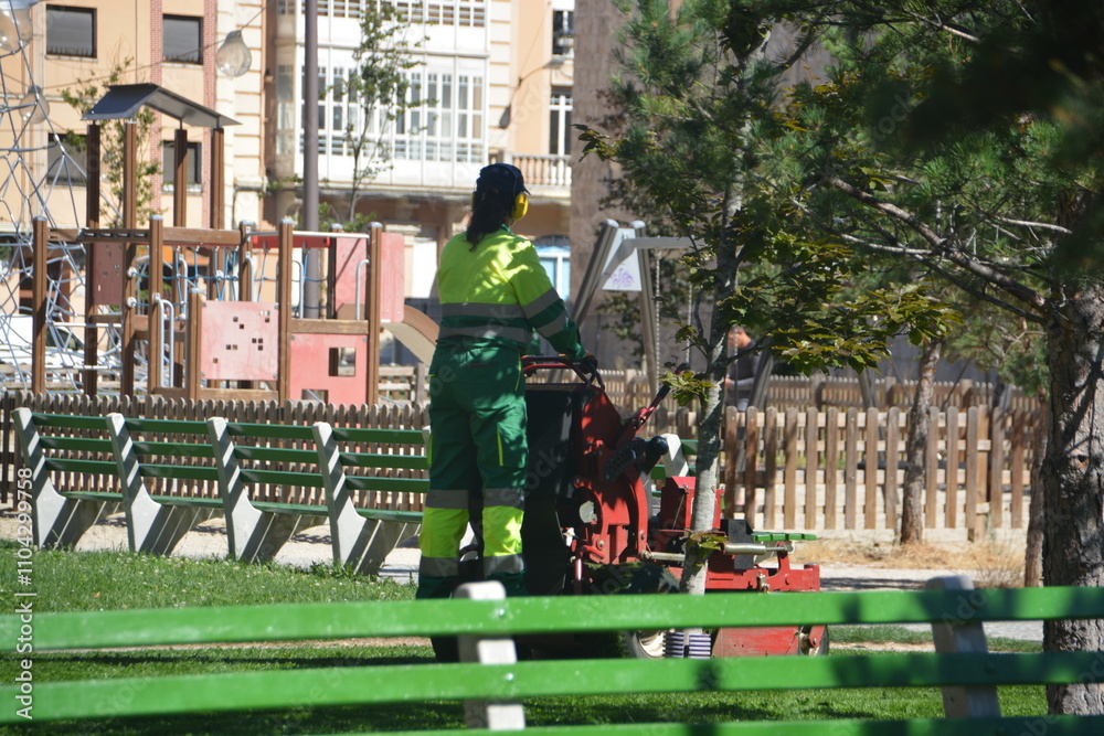 Jardinero cortando la hierba de un jardín público