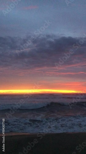 The sun sets over a calm beach, gentle waves wash over the shore. Golden times are on the horizon. photo