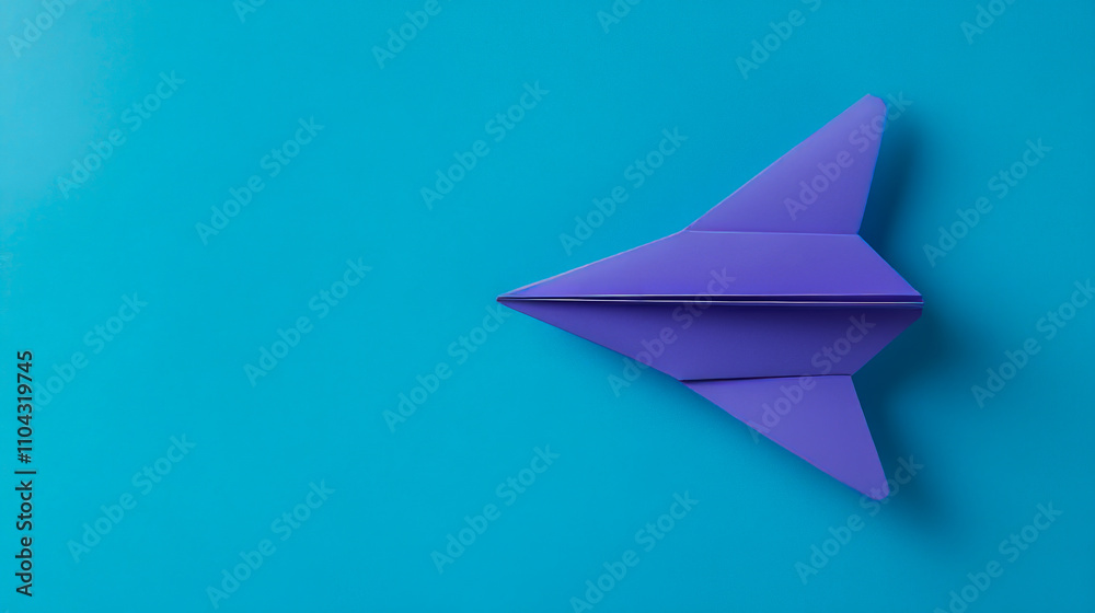 Purple origami airplane on vibrant blue background Purple origami airplane on vibrant blue background