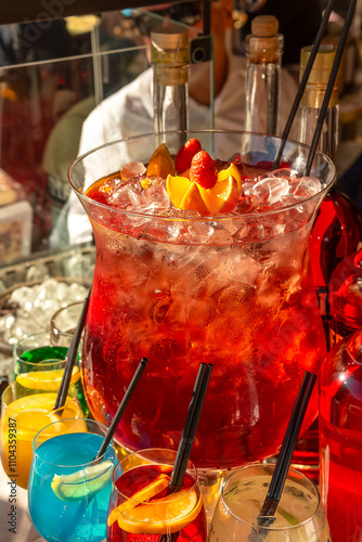 Obraz na płótnie Street trade. Large glass vessel with sangria with ice and colorful cocktails in glasses on the counter w salonie