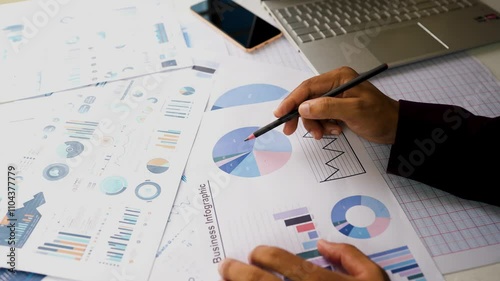 Business papers phone laptop pencil hand on table