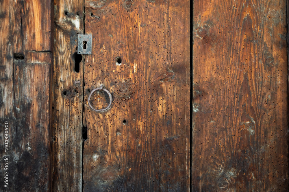 Vieille porte en bois vermoulu d'un chalet des Alpes suisse avec une serrure métalique Vieille porte en bois vermoulu d'un chalet des Alpes suisse avec une serrure métalique