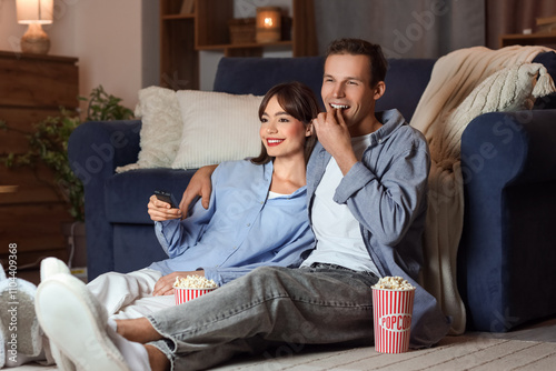 Young couple with popcorn w...
