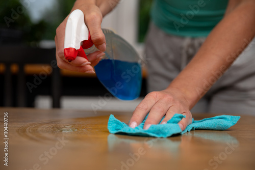 Tablou pe pânză The process of cleaning a wooden surface using a spray and a cloth is quite effe