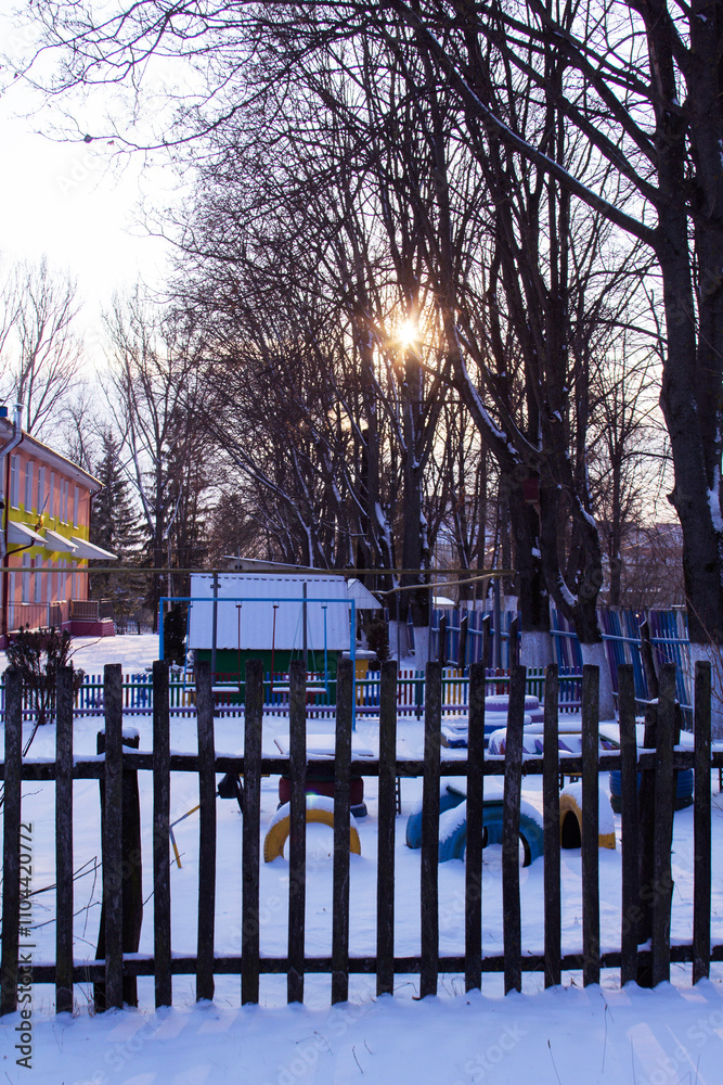 Winter landscape in the rays of the setting sun. City park.