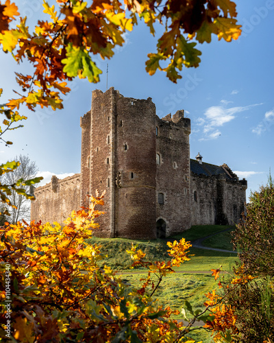 Doune Castle in Schottland im Herbst durch buntes Laub eingerahmt, bekannt aus Monty Python, Game of Thrones und Outlander, ein ikonischer Drehort in stimmungsvoller Naturkulisse photo