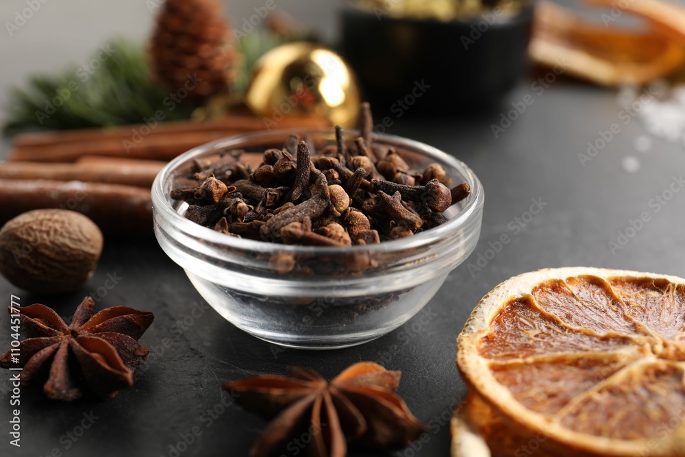 Different aromatic spices on black table, closeup. Christmas season