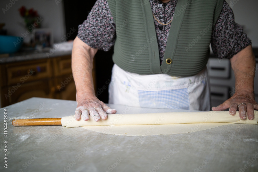 close up of grandmother rolling dough with a rolling pin. Elderly woman rolling out dough with a rolling pin close up of grandmother rolling dough with a rolling pin. Elderly woman rolling out dough with a rolling pin