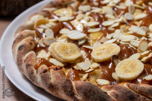 Banana pizza with dulce de leche and nuts photo