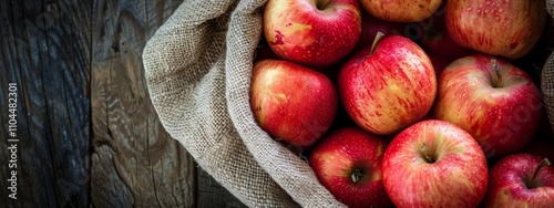 Fresh red apples in a rustic burlap sack photo