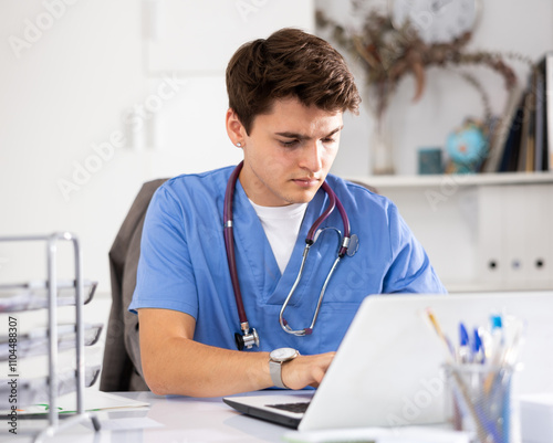 Bilde på lerret Focused doctor therapist works at a hospital computer, studying outpatient cards