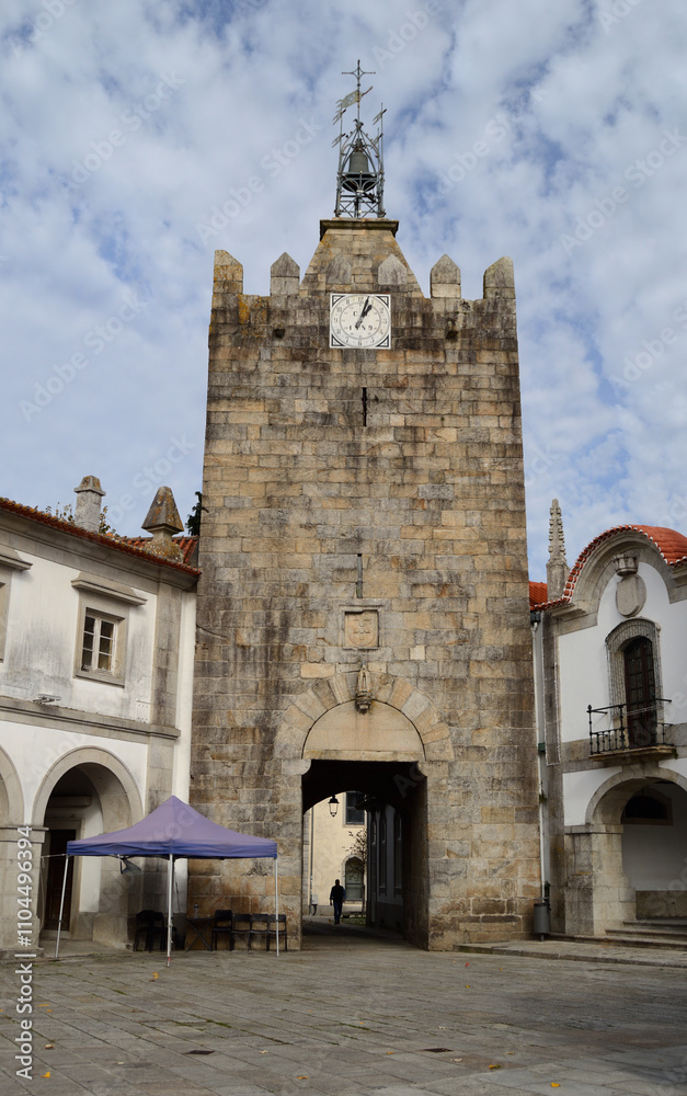 Obraz premium Clock tower and medieval gate in the city of Caminha, with the silhouette of a person passing by, Minho area located in the north of Portugal