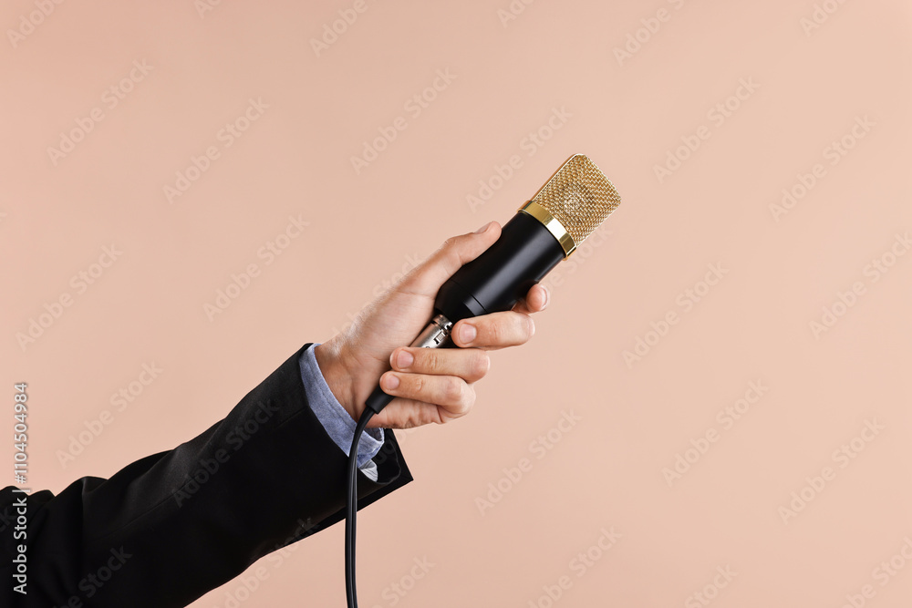 Fototapeta premium Man with microphone on beige background, closeup