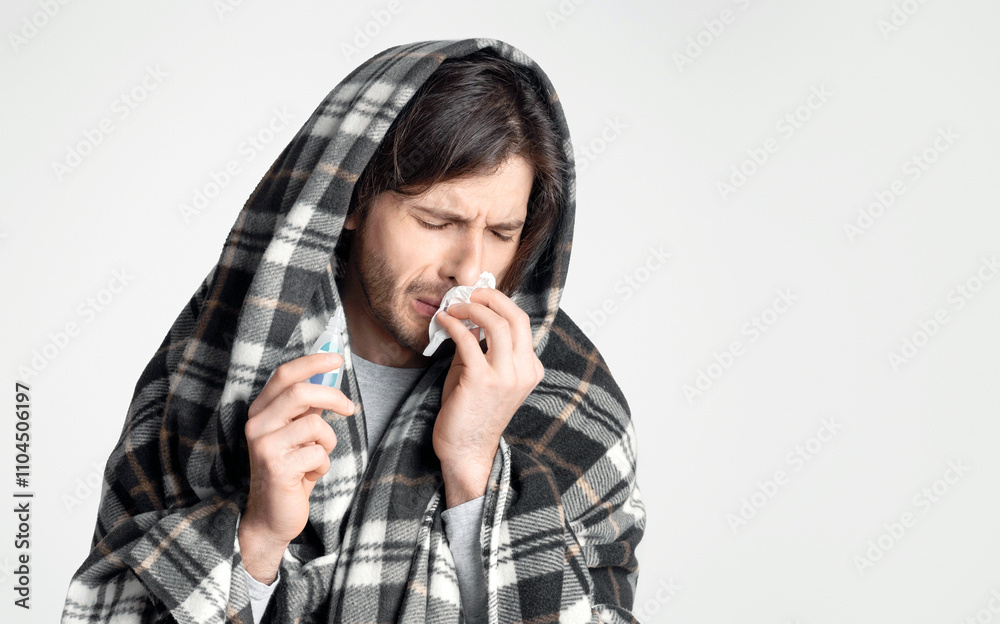 Sick man with in blanket napkin and drops for nose in hands, empty space Sick man with in blanket napkin and drops for nose in hands, empty space