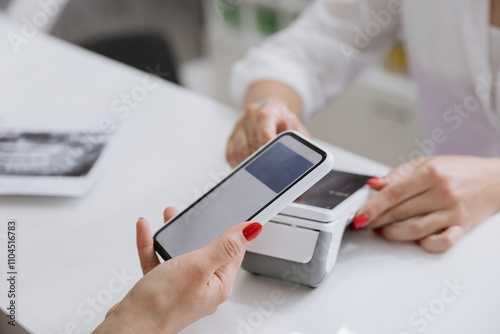 Contactless smartphone payment at a clinic reception desk for a seamless transaction