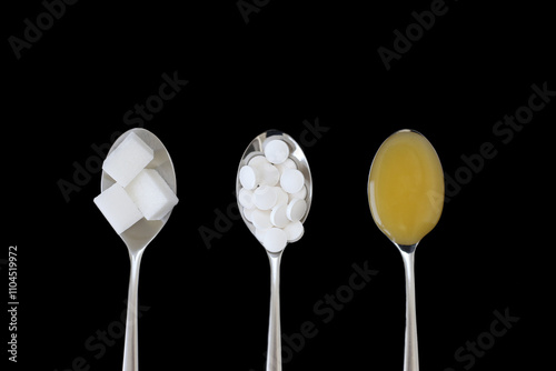 Three spoons with sugar, sweetener and honey on black background photo