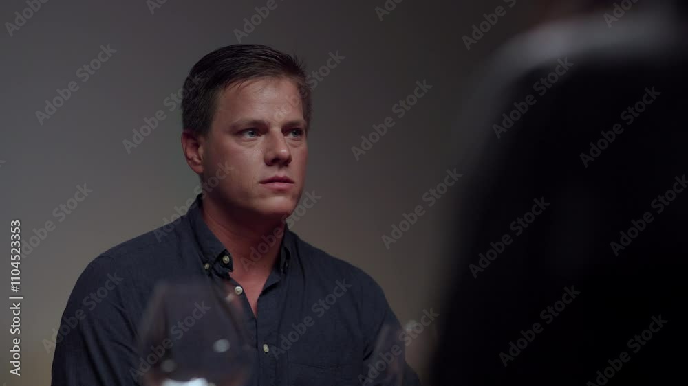 Good looking young man having a conversation with his friends while sitting at the restaurant. Guy gesturing hands on restaurant table Good looking young man having a conversation with his friends while sitting at the restaurant. Guy gesturing hands on restaurant table