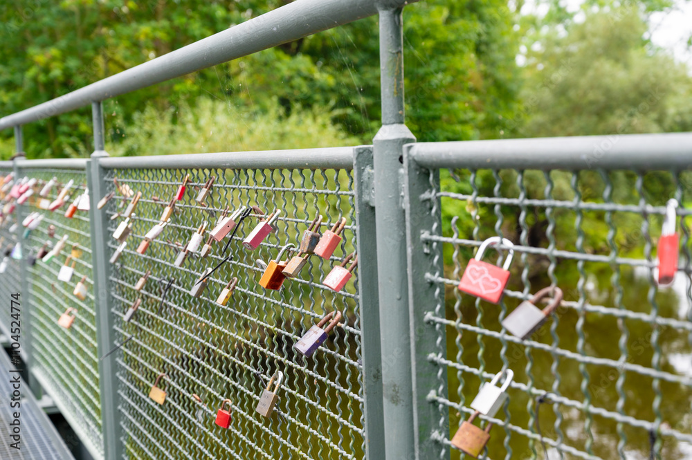 Locks attached to the fence of the bridge. Symbol of eternal love and fidelity. Concept of unbreakable friendship Locks attached to the fence of the bridge. Symbol of eternal love and fidelity. Concept of unbreakable friendship