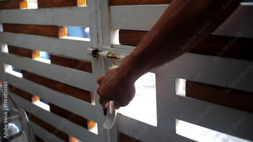 the activity of opening or closing iron and wooden fences in front of the house.