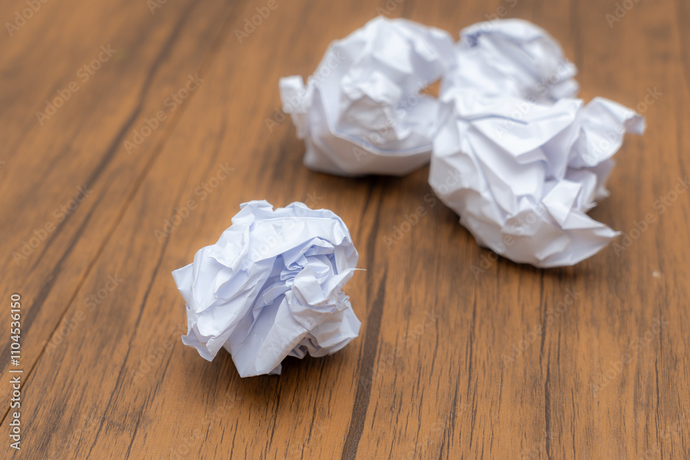 Writing concept - crumpled up paper wads with a sheet of white paper and pencil Writing concept - crumpled up paper wads with a sheet of white paper and pencil