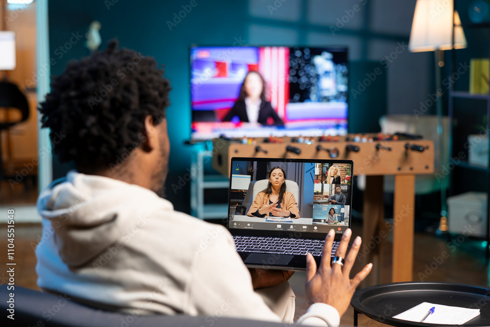 BIPOC man and coworkers in videoconference crosschecking analytics statistical data sets from apartment office. Businessman at home optimizing key performance indicators with colleagues in videocall BIPOC man and coworkers in videoconference crosschecking analytics statistical data sets from apartment office. Businessman at home optimizing key performance indicators with colleagues in videocall
