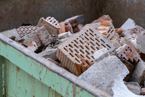 Broken clay ceramic bricks from a ruined wall lie scattered on a construction site, representing construction waste photo