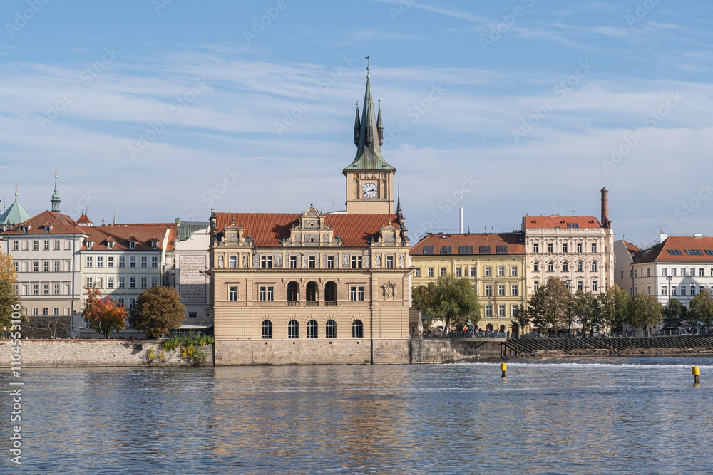 Fototapeta premium Autumn cityscape of Prague with a view of the Old Town. Gothic-style historic buildings are reflected in the Vltava River's calm waters.