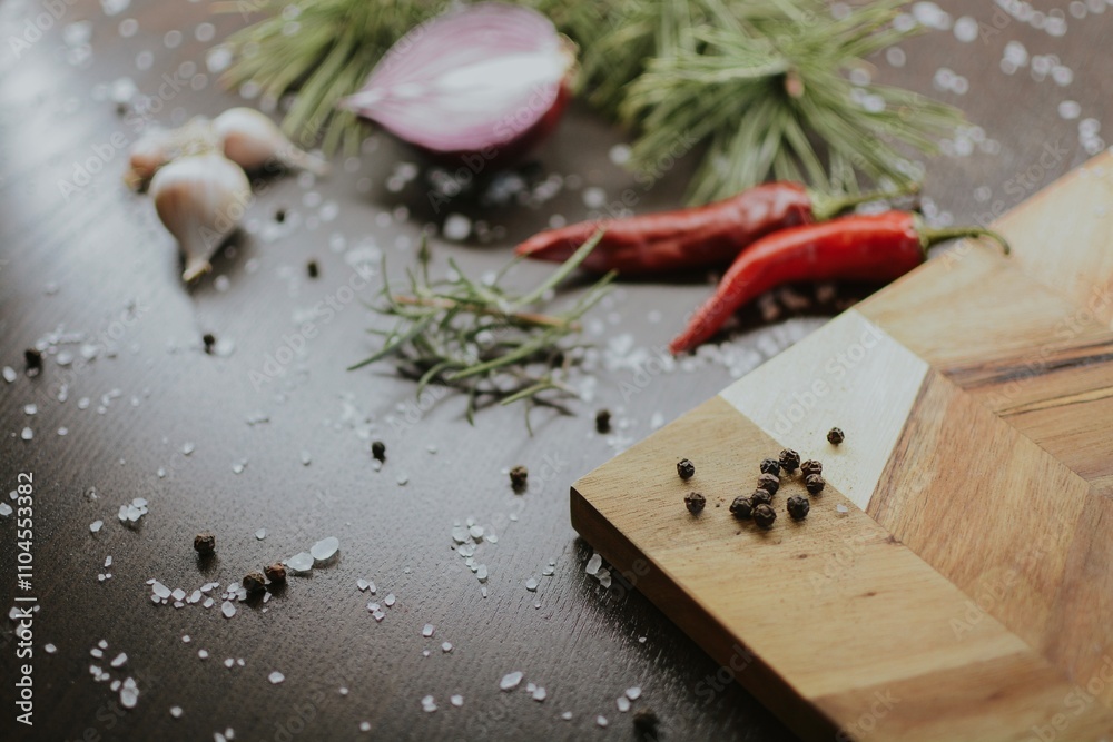 Coarse pepper on a wooden tray with salt, garlic, red onion, red pepper and rosemary for the chef Coarse pepper on a wooden tray with salt, garlic, red onion, red pepper and rosemary for the chef