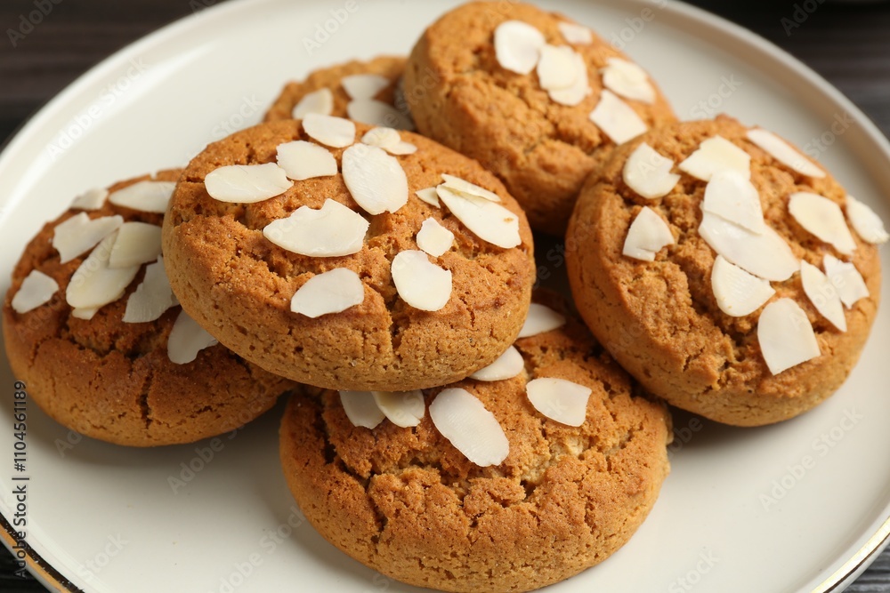 Tasty cookies with almond flakes on table, closeup