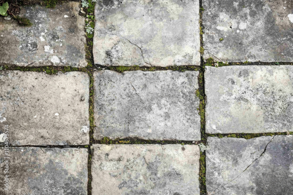 Obraz premium Worn stone pavement texture, aged gray slabs with visible cracks and faint mossy patches