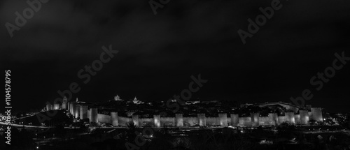 Obraz na plátně Illuminated nighttime scene showcasing the iconic medieval rampart wall and main entrance gate of Ávila, Spain