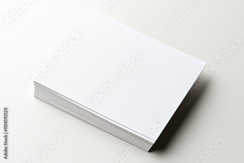 A stack of white paper is on a white surface