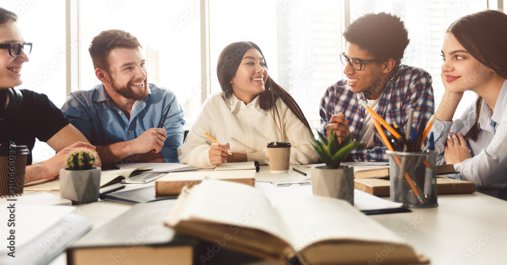 Education concept. University students preparing for exam, talking and drinking coffee in library Education concept. University students preparing for exam, talking and drinking coffee in library
