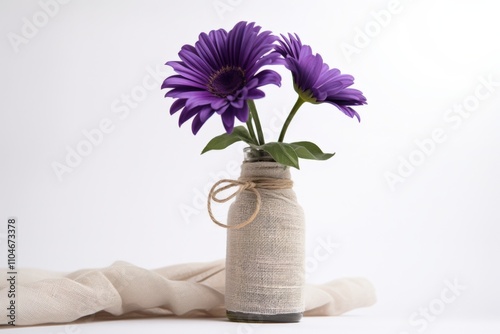 purple flowers in a rustic vase on a white background