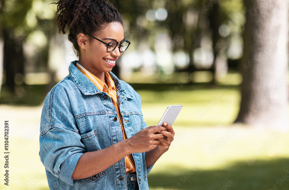 Happy Black Woman Holding Smartphone Reading Good News Message Walking Outside In Park. Mobile Application Concept. Copy Space Happy Black Woman Holding Smartphone Reading Good News Message Walking Outside In Park. Mobile Application Concept. Copy Space