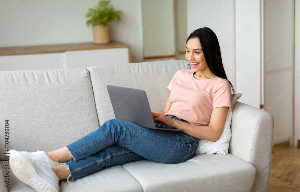 Joyful Woman At Laptop Making Video Call Sitting On Couch Indoors On Weekend. Online Communication Concept. Selective Focus Joyful Woman At Laptop Making Video Call Sitting On Couch Indoors On Weekend. Online Communication Concept. Selective Focus