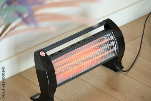 Modern electric infrared heater in living room, closeup photo