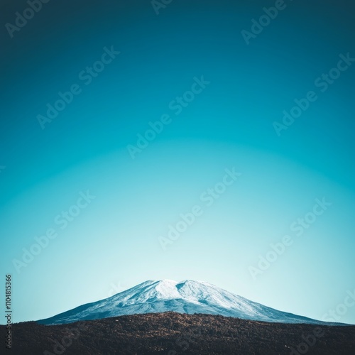 Snow-capped mountain peak against a vibrant blue sky. photo