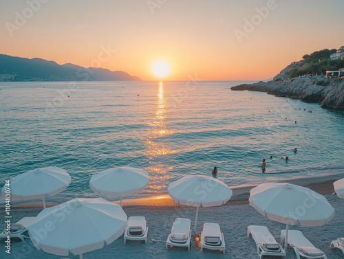 Serene Beach Coast with White Sun Umbrellas and Loungers at Sunset, People Enjoying the Ocean photo