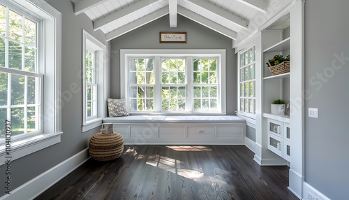 Sunroom with white windows, gray walls, dark wood floors, small window seat, white beamed ceiling, home decor.