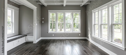 Sunroom with white windows, gray walls, dark wood floors, small window seat, white beamed ceiling, home decor style.