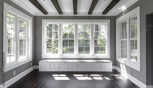 Sunroom with white windows, gray walls, dark wood floors, window seat, beamed ceiling, home decor style.