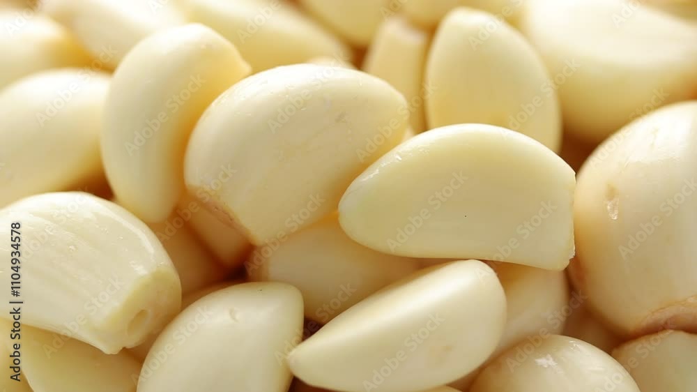 Heap of peeled garlic cloves rotating. Close-up shot Heap of peeled garlic cloves rotating. Close-up shot