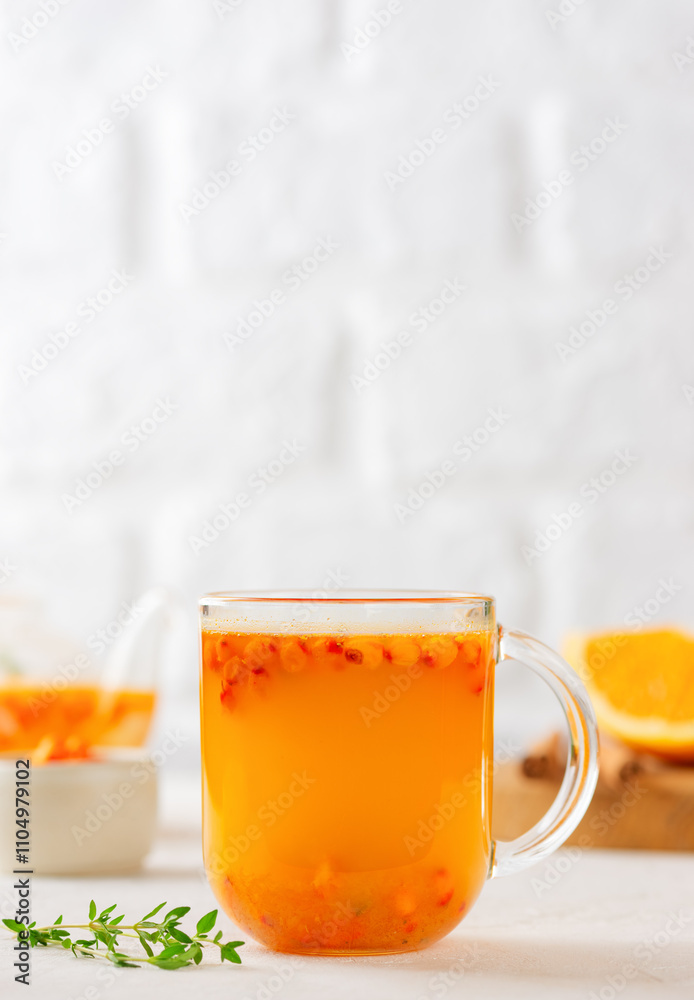 Sea buckthorn autumn tea with orange, thyme, honey and cinnamon in glass cups. Herbal vitamin tea. Vertical orientation. Sea buckthorn autumn tea with orange, thyme, honey and cinnamon in glass cups. Herbal vitamin tea. Vertical orientation.
