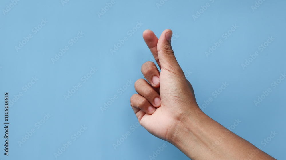 Finger heart. man hand with french manicure gesturing isolated on blue background Finger heart. man hand with french manicure gesturing isolated on blue background